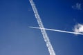 Passenger jet trails crossing in a blue sky Royalty Free Stock Photo