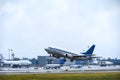 Passenger liner takes off into the sky from the airport runway in cloudy weather with rain