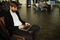 Passenger man sitting at the airport working in his laptop waiting his flight. Royalty Free Stock Photo