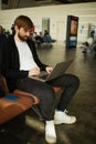 Passenger man sitting at the airport working in his laptop waiting his flight. Royalty Free Stock Photo