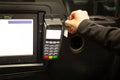 Passenger paying taxi fare with credit card in card reader.