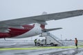 Passenger plane at airport in winter in blizzard.A gangway for landing air passengers at the base of a car pulls up to the door of Royalty Free Stock Photo