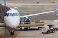 Passenger plane is being serviced by ground services near boarding gate bridge prior to takeoff