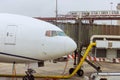 Passenger plane is being serviced by ground services prior to next takeoff at boarding gate bridge