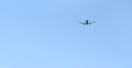 The passenger plane flies away into the blue sky. Back view Royalty Free Stock Photo
