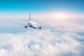 Passenger plane flies high above the clouds in the blue sky Royalty Free Stock Photo