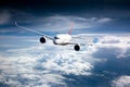 Passenger aircraft flies high above the clouds. Front view. Right heeling