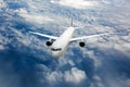 Passenger plane in flight. Aircraft flies high in the sky above the clouds. Front view of airplane Royalty Free Stock Photo