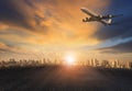 Passenger plane flying over urban building against beautiful sun Royalty Free Stock Photo