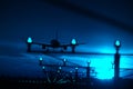 Silhouette of plane landing, runway lights, blue effect Royalty Free Stock Photo