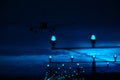 Silhouette of plane landing, runway lights, blue effect Royalty Free Stock Photo