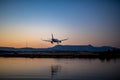 Passenger plane landing at Corfu airport at sunset Royalty Free Stock Photo