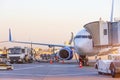 Passenger plane parked at the airport. Refueling operation in action during sunset. Fuel kerosene tanker vehicle. Handling and