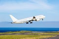 Passenger plane takes off from the airport runway. Ocean at the background. Royalty Free Stock Photo