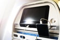 Passenger on a plane using the charger for charge smart phone during flight. Charging station on plane
