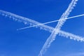 a passenger plane with vapour trails in the blue sky Royalty Free Stock Photo