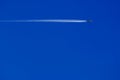 a passenger plane with vapour trails in the blue sky Royalty Free Stock Photo