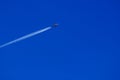 a passenger plane with vapour trails in the blue sky Royalty Free Stock Photo