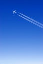 a passenger plane with vapour trails in the blue sky Royalty Free Stock Photo