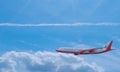 Passenger plane White red stripes flying in the sky on a bright blue day, white clouds in the daytime. To view, see the top of the