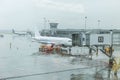 Passenger planes on the airfield near the airport building on a rainy gloomy day. Sleeve for the passage of passengers. Tourism