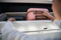 Passenger pushing pink baggage in plane overhead bin Royalty Free Stock Photo