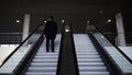 Passenger riding on the escalator up to the station of the ground metro. Media. Rear view of a young businessman on the Royalty Free Stock Photo