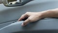 Passenger's hand holds armrests beside the door of car from the inside.