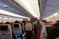 Passenger seat, Interior of airplane with passengers sitting on seats and stewardess walking the aisle in background