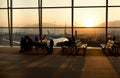 Passenger sitting in a lobby airport waiting for flight in silhouette Royalty Free Stock Photo