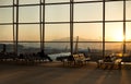 Passenger sitting in a lobby airport waiting for flight in silhouette Royalty Free Stock Photo