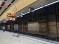 A passenger standing on platform 4B behind the yellow line in Taipei Train Station waiting for a southbound train during