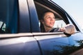 Passenger in taxi or woman in car sitting on the backseat looking outside the window. Happy female customer in cab.