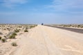 Passenger tourist coach driving in the distance in deserted highway on salt dried lake, road from Algeria to Tunisia on Chott El