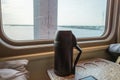 A passenger train car. the interior of the sleeping car of the train. Thermos on the table. the concept of travel and Royalty Free Stock Photo