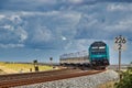 Passenger train on curved rail track under grey sky