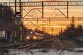 The passenger train goes on the railway tracks towards the station, a view of the communication route at sunset Royalty Free Stock Photo