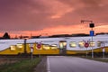 A passenger train passing through an unguarded railway crossing well marked, evening sky illuminated by the setting sun Royalty Free Stock Photo