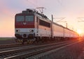 Passenger train on railway at sunset Royalty Free Stock Photo