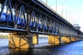 The passenger train  rides along a two-level bridge and a railway across the Dnieper  River in the Dnipro city in spring. Royalty Free Stock Photo