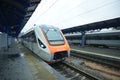 Passenger train standing on the railway track, empty platforms of the railway station Royalty Free Stock Photo