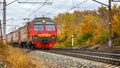 Passenger train with wagons Ed4m moves by rail through the beautiful Autumn Forest