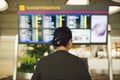 Passenger traveling at the flight information board in airport terminal waiting hall area checking time for departure-arrival and Royalty Free Stock Photo