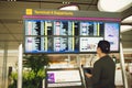 Passenger traveling at the flight information board in airport terminal waiting hall area checking time for departure-arrival and Royalty Free Stock Photo