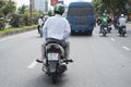 A passenger uses Grab moto-taxi services in a street of Ho Chi Minh City.