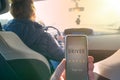 Passenger using smart phone app to rate a taxi or modern peer to peer ridesharing driver