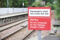 Passenger warning sign at railway train station stating do not trespass or penalty fine will be issued if you cross the rail line