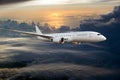 Passenger wide body plane flying high above the sunset clouds. Side view. Royalty Free Stock Photo