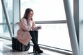 Passenger woman in airport waiting for air travel.