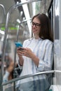 Passenger young woman using mobile smart phone chatting in social networks in subway train at metro Royalty Free Stock Photo